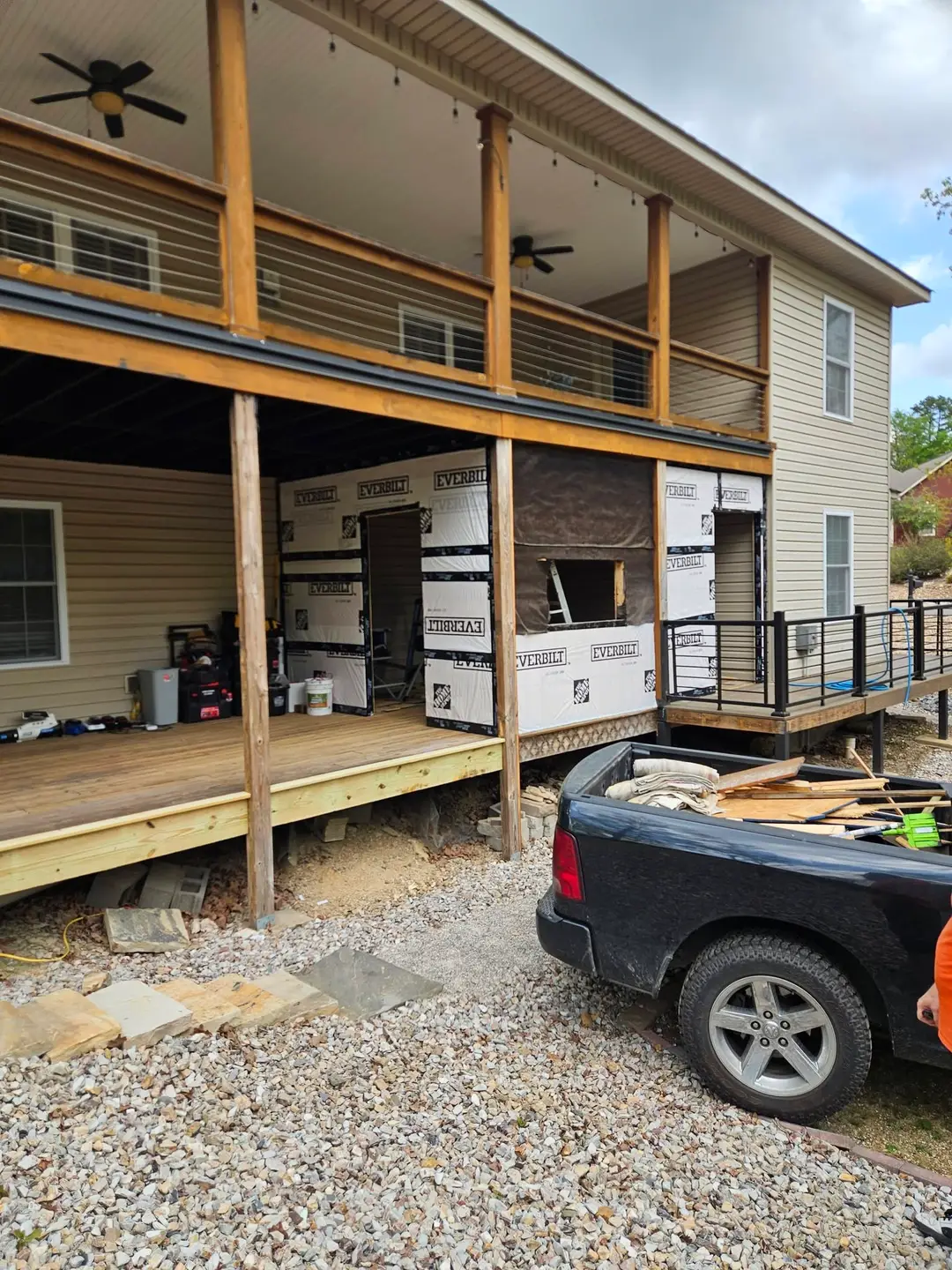 After: under-deck bays framed and wrapped in house wrap, with new deck boards along the edge.