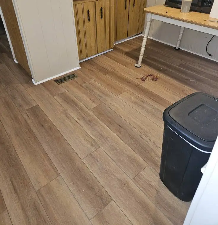 After: light oak LVP running under the sink cabinets and out through the doorway.