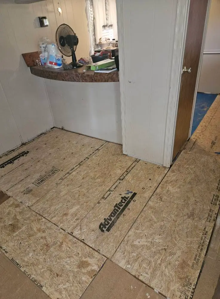 During: AdvanTech subfloor sheets screwed down in front of a rounded bar counter, ready for LVP.