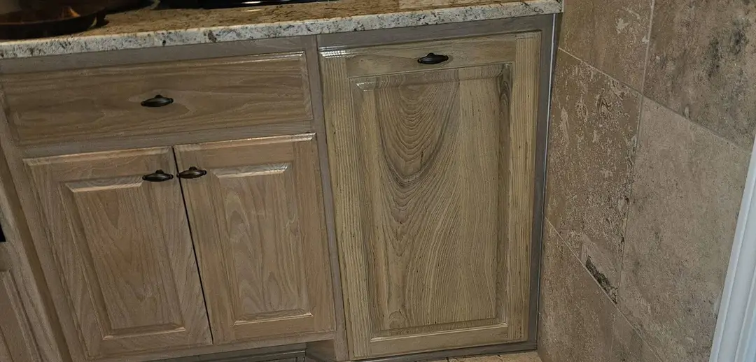 After: built-in pull-out trash cabinet fitted into the run, its door matched to the existing cabinet finish.