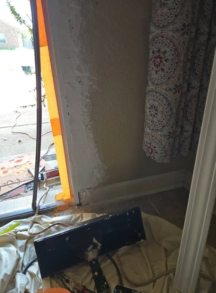 During: door-side wall skim coated with joint compound, taped off at the jamb and left to dry.