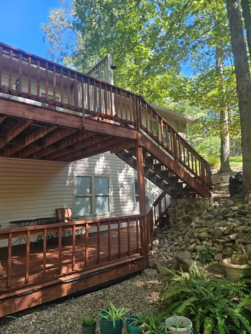 After: two-story deck and open stair stained red-brown from the upper railing down to the lower boards.