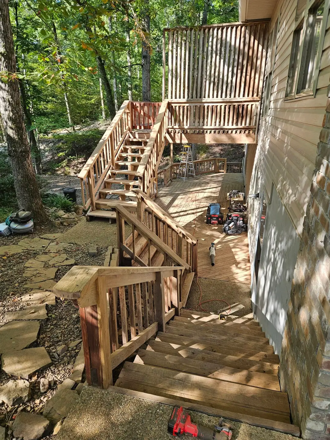 Before: bare sanded deck, stair and railing waiting for stain, seen from the top of the steps.