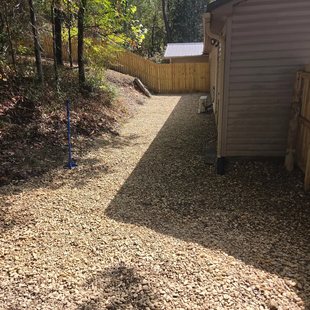 After: a gravel drainage run laid the length of the house and graded to carry roof water away from the foundation.