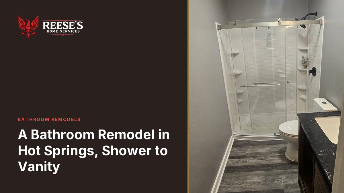 Neo-angle shower with a sliding glass door and a stone-topped vanity on gray plank flooring.