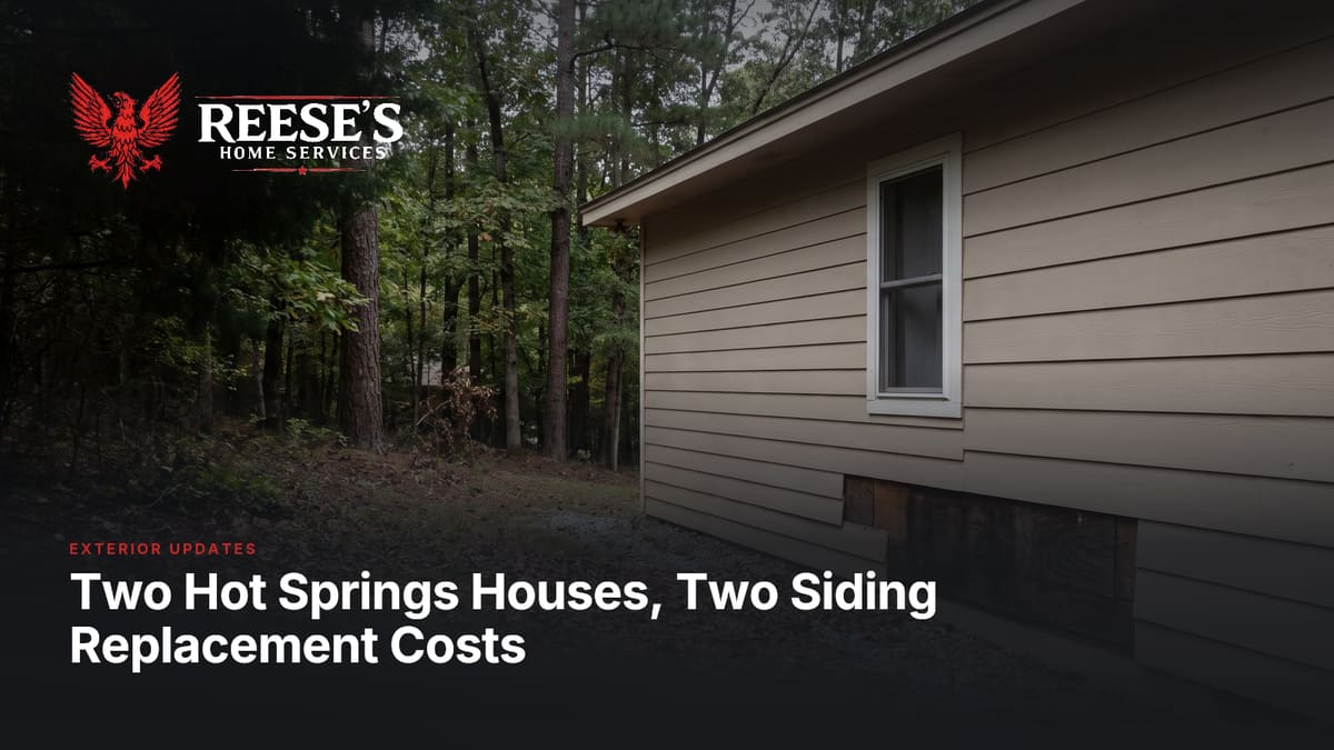 Tan lap siding along a house wall beside the woods, with a strip of dark boards showing near the foundation.