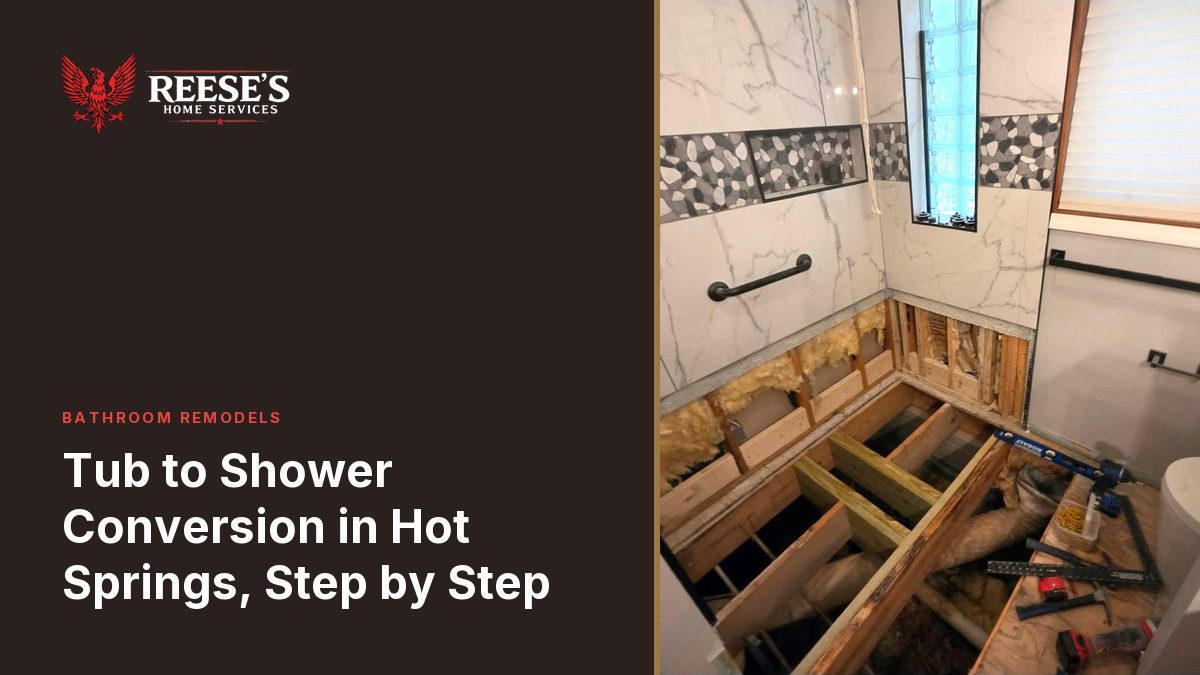 Open floor joists where the old shower pan and subfloor came out, tile still standing on the walls above.