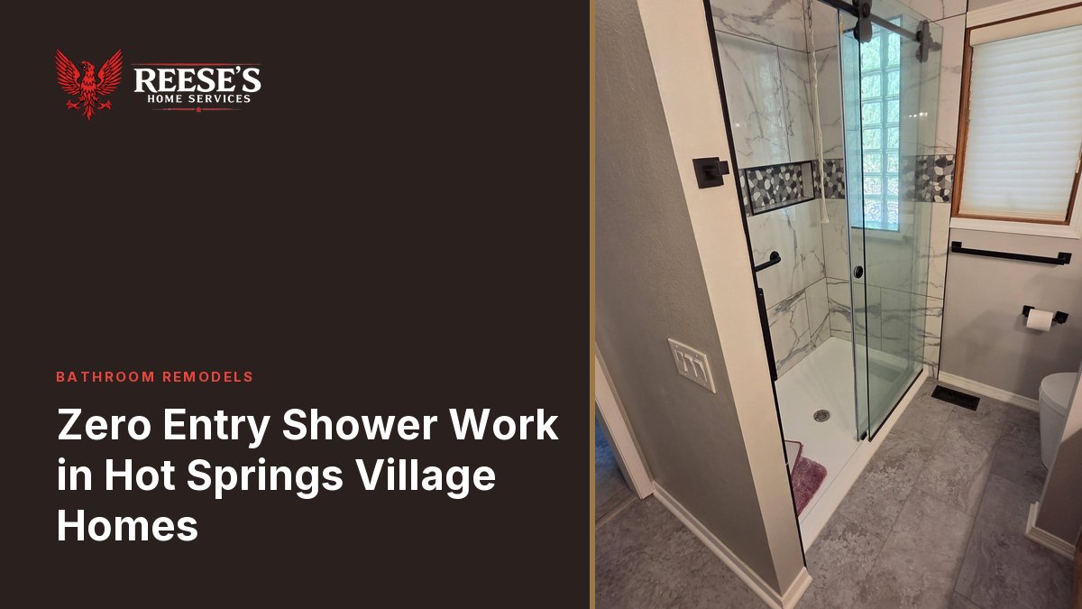 Rebuilt walk-in shower tiled in marble-look porcelain with a pebble mosaic band and a frameless glass door.